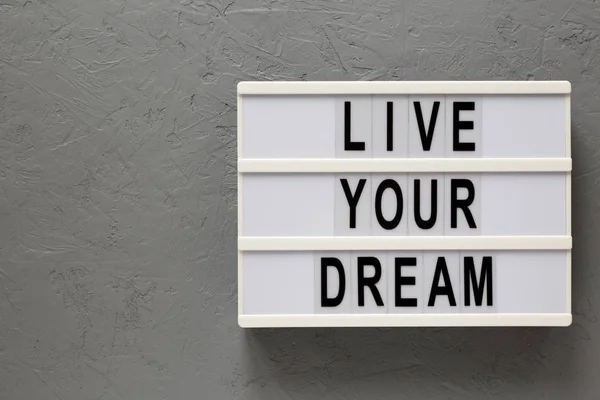 'Vivez votre rêve 'mots sur une planche moderne sur un fond gris , — Photo