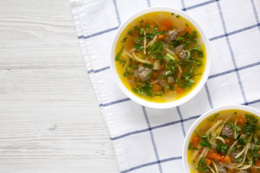 Beyaz ahşap arka planda beyaz bir kâse içinde ev yapımı Sopa La Minuta. Dümdüz, tepeden, yukarıdan. Boşluğu kopyala.