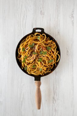 Üst manzara, ev yapımı Bucatini beyaz ahşap bir masada dökme demir bir tavada Amatriciana Pasta. Düz uzanın, başınızın üstünde. 