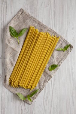 Beyaz ahşap bir yüzey üzerinde pişmemiş organik Bucatini Pasta, üst manzara. Yukarıdan, düz, üstten.