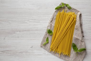 Beyaz ahşap arka planda pişmemiş organik Bucatini Pasta, üst manzara. Yukarıdan, dümdüz, tepeden. Metin için boşluk.