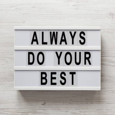 Beyaz ahşap bir yüzeyde, ışık kutusunda her zaman en iyi sözlerinizi kullanın. Yukarıdan, dümdüz yatıyordu. Yakın plan..