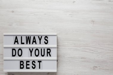 Beyaz ahşap arka planda, ışık kutusunda her zaman en iyi sözlerinizi kullanın. Yukarıdan, dümdüz yatıyordu. Boşluğu kopyala.