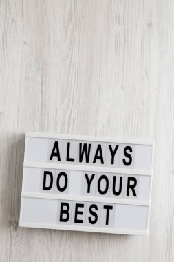 Beyaz ahşap bir yüzeyde, ışık kutusunda her zaman en iyi sözlerinizi kullanın. Yukarıdan, dümdüz yatıyordu. Boşluğu kopyala.