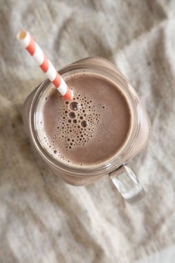 Ev yapımı New England çikolatalı milkshake üzerinde cam kavanoz bardağı. Üst manzara, genel giderler, düz yatış. Yakın plan..