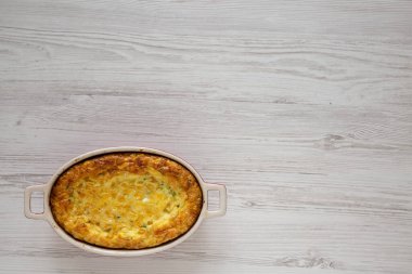 Beyaz ahşap bir masada ev yapımı peynirli puding güveci. Dümdüz, tepeden, yukarıdan. Boşluğu kopyala. 