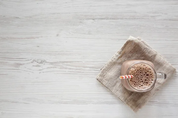 Beyaz Ahşap Arka Planda Cam Kavanozda Yapımı Çikolatalı Milkshake Yukarıdan — Stok fotoğraf