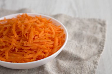 Beyaz kasede doğranmış havuç, düşük açılı görüş. Boşluğu kopyala.