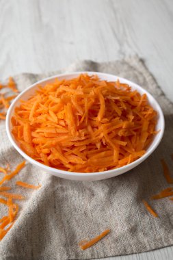 Beyaz kasede doğranmış havuç, düşük açılı görüş. Boşluğu kopyala.