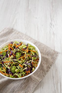 Ev yapımı çiğ brokoli salatası beyaz bir kasede, düşük açılı. Boşluğu kopyala.