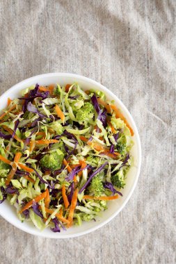 Ev yapımı çiğ brokoli salatası beyaz bir kâse içinde, üst manzara. Yukarıdan, dümdüz yatıyordu. Metin için boşluk.