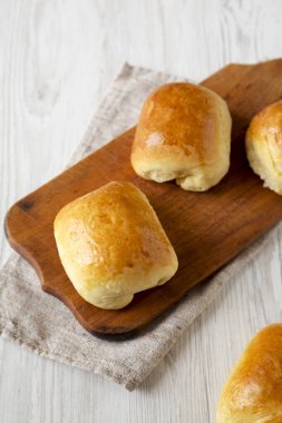 Beyaz ahşap arka planda, ahşap bir tahtanın üzerinde ev yapımı Bierocks bifteği. Yakın plan..