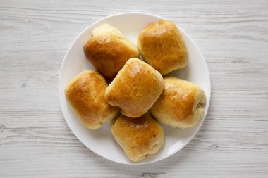 Beyaz ahşap arka planda beyaz bir plaka üzerinde ev yapımı Rus Bierocks bifteği. Dümdüz, tepeden, yukarıdan. 