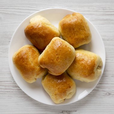 Beyaz ahşap bir masada beyaz bir tabakta ev yapımı Rus Bierocks bifteği. Dümdüz, tepeden, yukarıdan. 