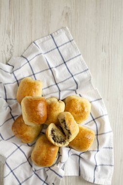 Beyaz ahşap bir masa üzerinde ev yapımı Rus Bierocks bifteği. Dümdüz, tepeden, yukarıdan. Boşluğu kopyala.