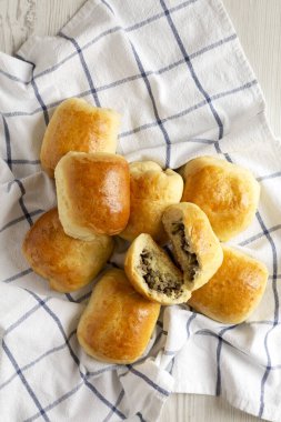 Beyaz ahşap bir masa üzerinde ev yapımı Rus Bierocks bifteği. Dümdüz, tepeden, yukarıdan. 