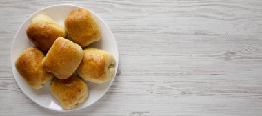 Beyaz ahşap arka planda beyaz bir plaka üzerinde ev yapımı Rus Bierocks bifteği. Dümdüz, tepeden, yukarıdan. Metin için boşluk.