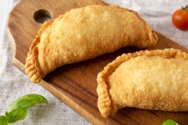 Ev yapımı İtalyan Panzerotti Calzone. Kırsal ahşap bir tahta üzerinde. Düşük açılı. Yakın plan..