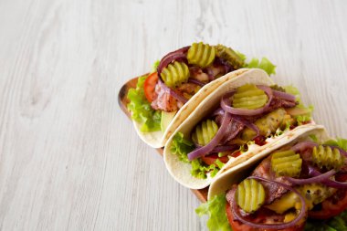 Beyaz ahşap bir yüzey üzerinde tahta bir tahta üzerinde ev yapımı çizburgerli taco. Düşük açılı. Metin için boşluk.