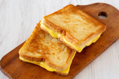 Homemade Grilled Cheese Sandwich on a rustic wooden board on a white wooden background, low angle view. Close-up. clipart
