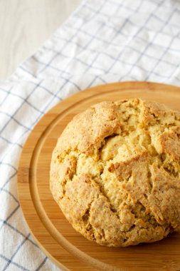 Yuvarlak bir bambu tahtada ev yapımı İrlanda sodası ekmeği, yan görüş. Boşluğu kopyala.