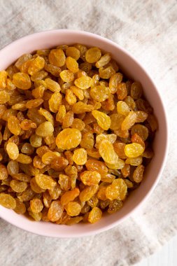 Pembe bir kasede altın kuru üzümler, üst manzara. Dümdüz, tepeden, yukarıdan. 