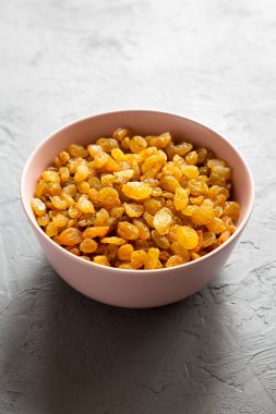 Gri arka planda Pembe Kâse 'de Altın Kuru Üzümler, düşük açılı görünüm. 