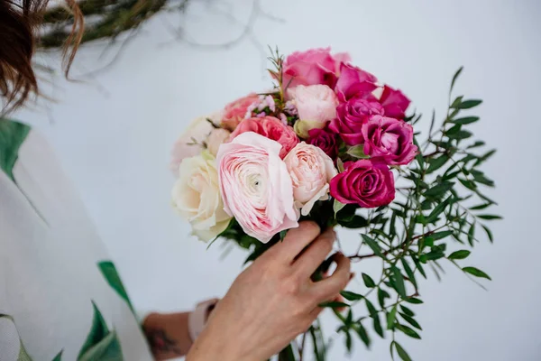 Çiçekçi bir buket yapar.