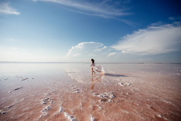 Hermosa mujer en un lago rosa . —  Fotos de Stock