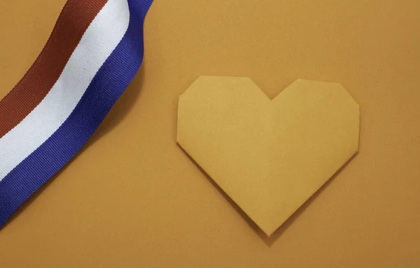 Hollanda turuncusu kağıt kalpli ve kırmızı beyaz ve mavi kurdeleli. Hollanda 'da Krallar Günü ya da spor müsabakaları için.