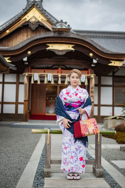 Woman dressed in traditional japanese costume walking under tori — Stock Photo, Image