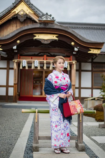 Женщина в традиционном японском костюме ходит под тори — стоковое фото