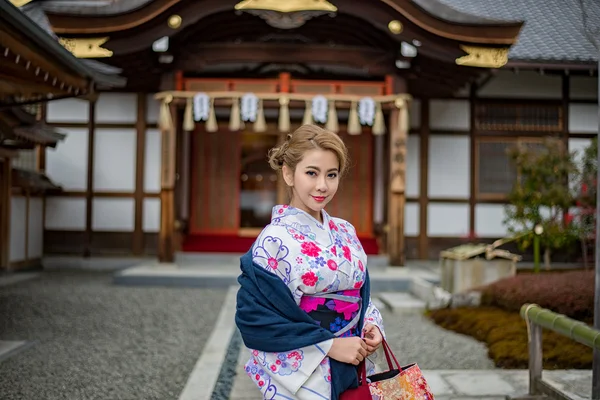 Donna vestita in costume tradizionale giapponese passeggiando sotto tori — Foto Stock