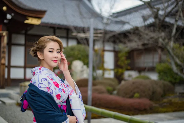 Frau in traditioneller japanischer Tracht geht unter Tori — Stockfoto