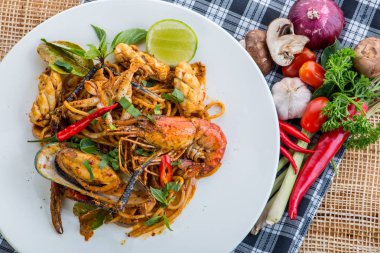 Spagetti deniz ürünleri ile baharatlı karıştırın kızarmış ve whit üzerinde fesleğen yaprağı