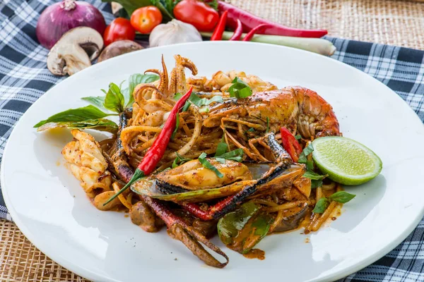 Pittige roer gebakken spaghetti met zeevruchten en basilicum bladeren op whit — Stockfoto