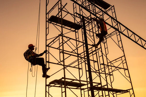 Siluet Mühendisleri Mimarlarla görüşüyor inşaat sahasında planlama yapıyor yüksek zeminde ağır sanayi ve güvenlik kavramı üzerinde çalışıyor 