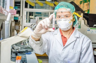 Coronavirus covid 19 salgın hastalığı. Doktor ya da laboratuvar teknisyeni Tayland hastanesindeki laboratuvarda kan örneği tüpü tutuyor.