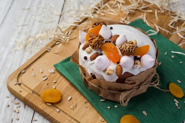 Osterkuchen (Brot) dekoriert mit Bonbons, getrockneten Aprikosen und Sonnenblumenkernen auf hölzernem Hintergrund. Urlaubskonzept — Stockfoto