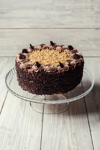 Pastel vegano de chocolate negro con caramelos y nueces en respaldo de madera — Foto de Stock