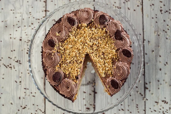 Veganer Kuchen aus dunkler Schokolade mit Bonbons und Nüssen auf Holzgrund — Stockfoto