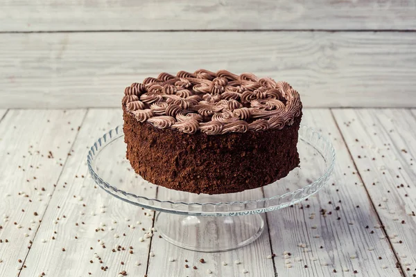 Veganer Kuchen aus dunkler Schokolade mit Bonbons und Sahne auf Holzrücken — Stockfoto