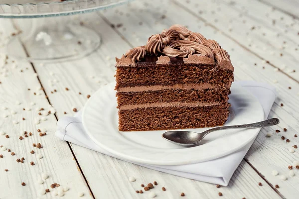 Pastel vegano de chocolate negro con caramelos y crema en respaldo de madera — Foto de Stock