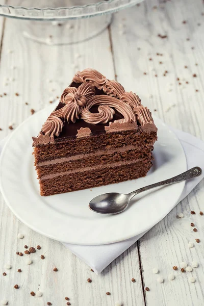 Pastel vegano de chocolate negro con caramelos y crema en respaldo de madera — Foto de Stock