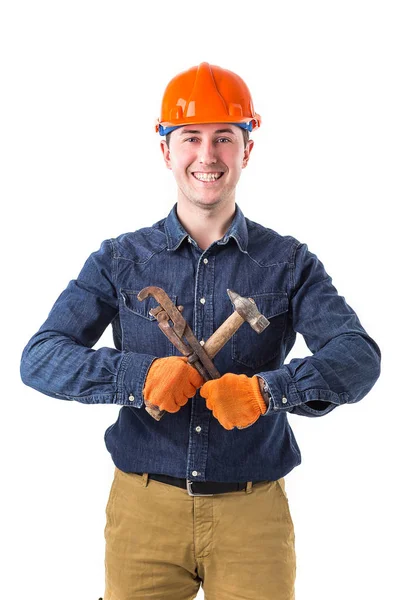 Sorrindo reparador (construtor) no capacete e com um martelo e uma chave na mão isolado no fundo branco — Fotografia de Stock