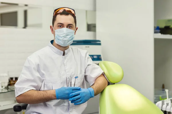 Homem dentista em pé sobre o fundo do consultório médico. Saúde, profissão, estomatologia e medicina conceito — Fotografia de Stock