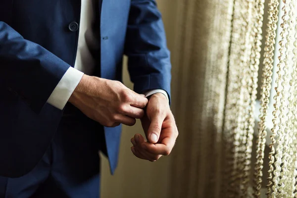 Empresario lleva una chaqueta, manos masculinas primer plano, novio preparándose en la mañana antes de la ceremonia de boda — Foto de Stock