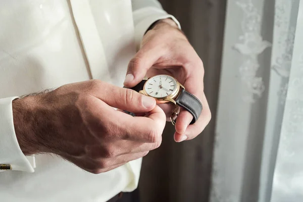 businessman checking time on his wrist watch, man putting clock on hand,groom getting ready in the morning before wedding ceremony