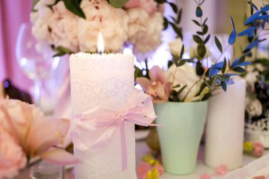 çiçek vazo ve bir büfe masa üzerinde yanan mum