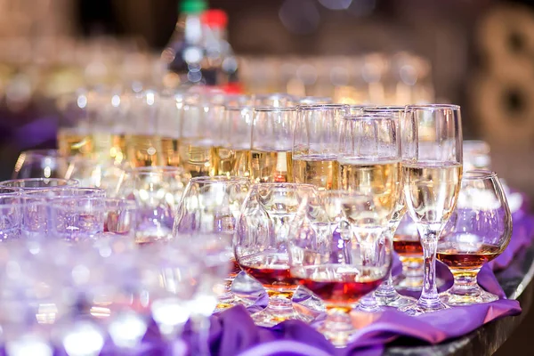 out catering, glasses with white and red wine, champagne, whiskey, juice and mineral water are on  table for the guests of  event